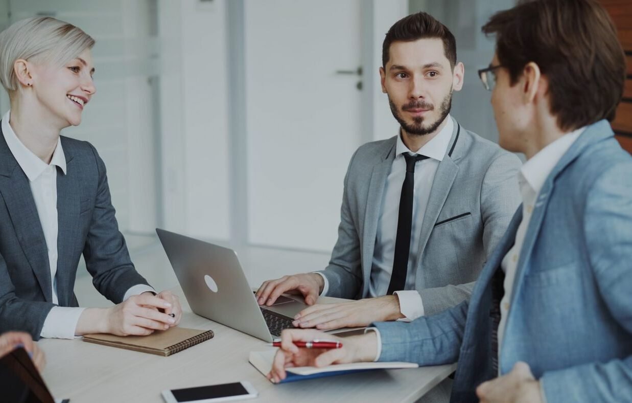 Professionals met laptop en notitieblok aan tafel