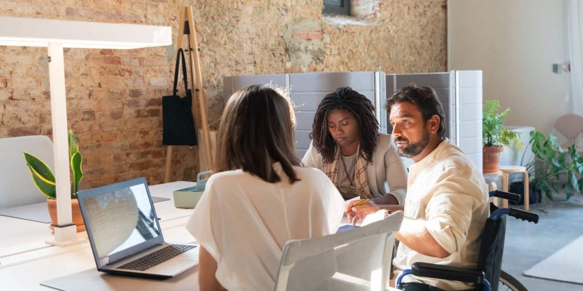A diverse office team discusses ideas in a modern workspace, enhancing collaboration.